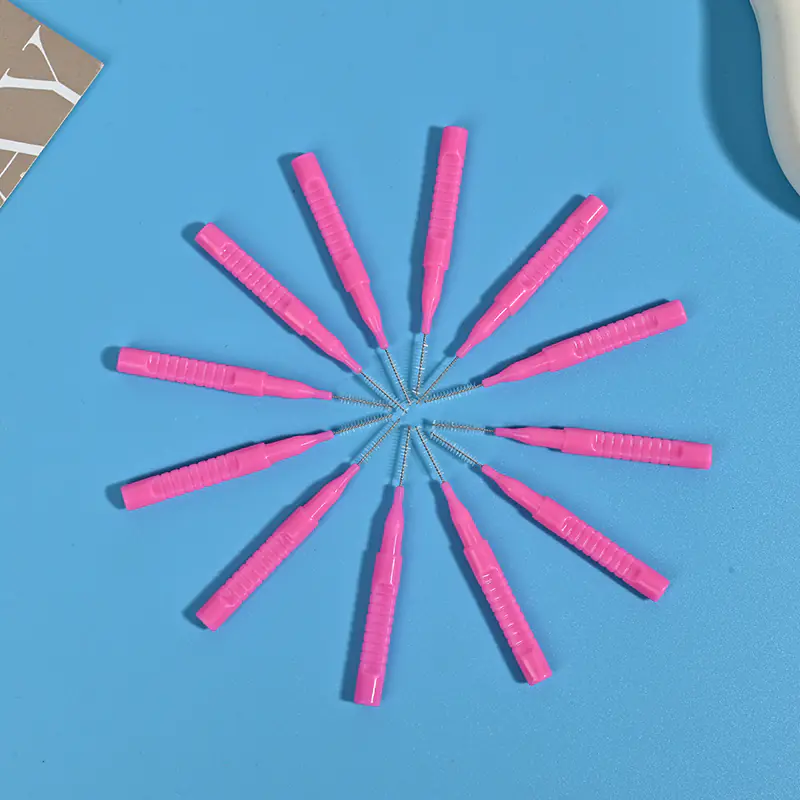 I-Type interdental brushes in multiple colors (pink, blue, red) with straight handles and tapered bristles, organized in a reusable storage box