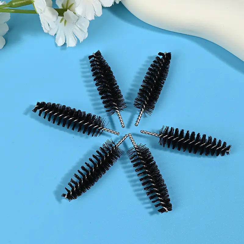 Black mascara brush heads with dense spiral bristles and twisted metal wire core, designed for professional eyelash application, OEM manufacturing, and bulk B2B cosmetic supply.