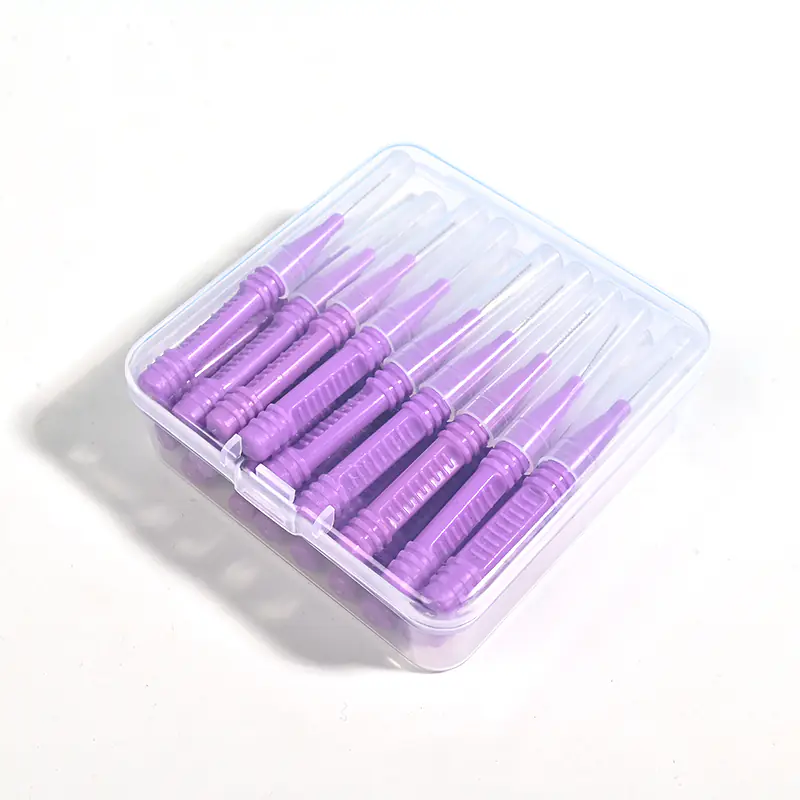 Top-down view of bulk purple interdental brushes in clear storage box, ready for wholesale distribution