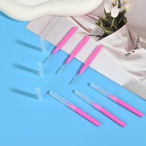 Pink handle interdental brushes with and without clear caps - close-up view showing metal bristles for interdental cleaning