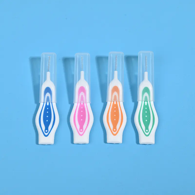 Four assorted color non-slip straight interdental brushes with dust caps arranged horizontally on blue background, portable oral care interdental cleaner bulk wholesale