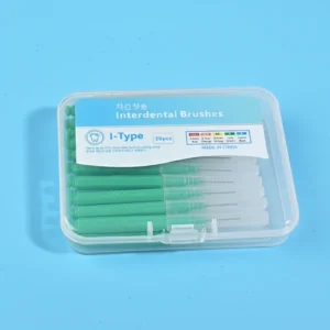 Close-up transparent plastic box filled with green straight I-type interdental brushes, bilingual Korean English label with full ISO size color specification chart on solid light blue background
