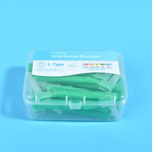 Close-up transparent plastic box filled with green L-type interdental brushes, bilingual Korean English label with full ISO size color specification chart on solid light blue background