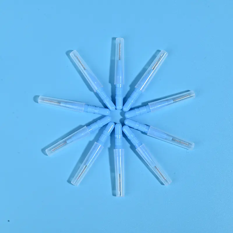 Nine light blue disposable interdental brushes with transparent protective caps arranged radially on light blue background