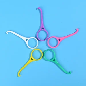 Five colorful plastic orthodontic brace remover hooks arranged radial star shape on solid bright blue background