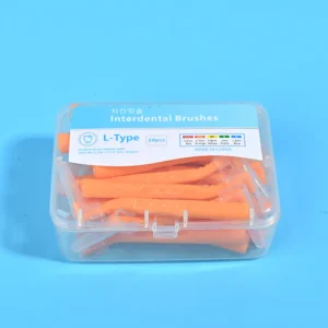 Close-up transparent plastic box filled with orange L-type interdental brushes, bilingual Korean English label with full ISO size color chart on solid light blue background