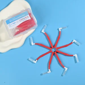 Red L-type MD interdental cleaners arranged radial star shape with clear plastic packaging box on beige pad and solid blue background