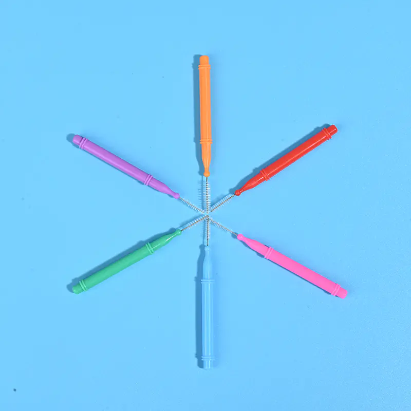 Six colorful push pull telescopic I-type interdental brushes arranged radial star shape on solid light blue background