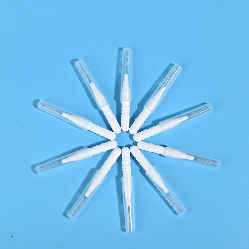 Nine white disposable interdental brushes with transparent protective caps arranged radially on light blue background