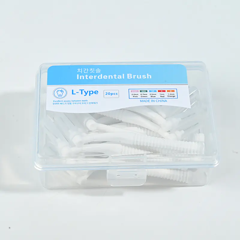 Close-up transparent plastic box filled with white L-type interdental brushes, bilingual Korean English label with full ISO size color chart on solid white background