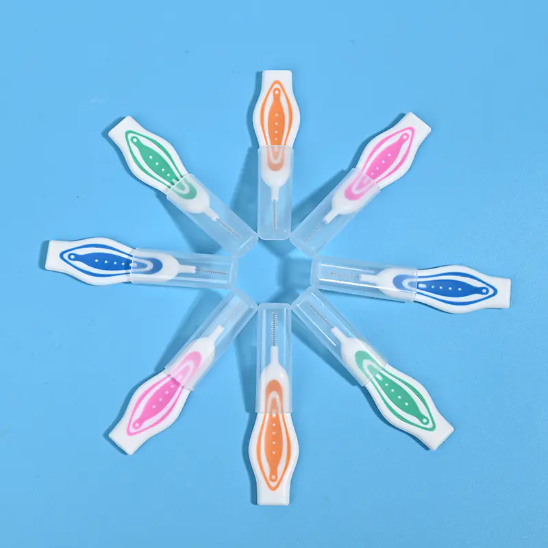 Color coded straight handle interdental brushes with transparent protective caps arranged in star shape on light blue background, portable travel dental cleaning tools wholesale from Qingdao factory