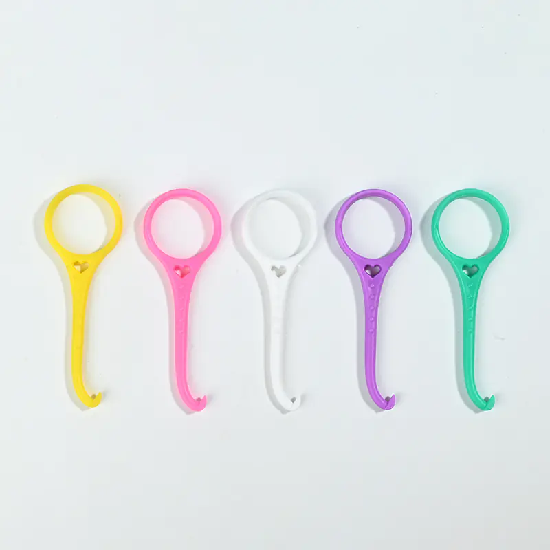 Five different color plastic invisible braces remover hooks lined up side by side on plain white background