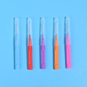 Five assorted color retractable I-type interdental brushes with transparent protective dust cap lined in a row on plain white background