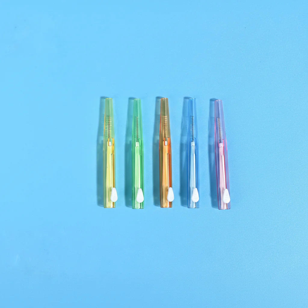 Five assorted translucent color sliding I-type interdental cleaners lined vertically on bright blue background