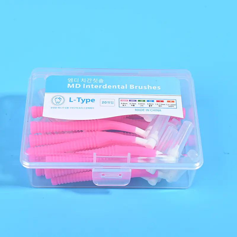 2-pink-l-type-md-interdental-brush-20pcs-clear-box-closeup-blue-bg.jpg Close-up front view of clear plastic box filled with pink L-type MD interdental brushes, bilingual Korean English label with full ISO size chart on blue background