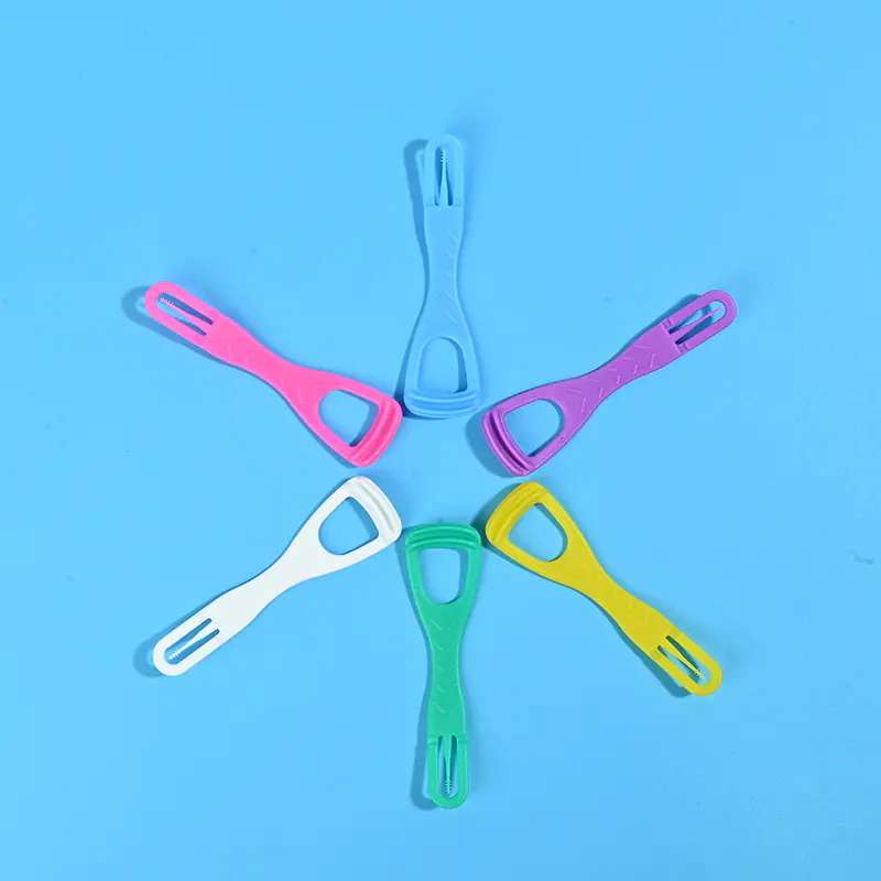Six multicolor plastic tongue scrapers arranged radial star shape on solid light blue background
