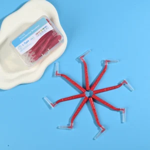 Red L-type interdental cleaners arranged radial star shape next to original clear plastic packaging box on irregular beige pad and bright blue background