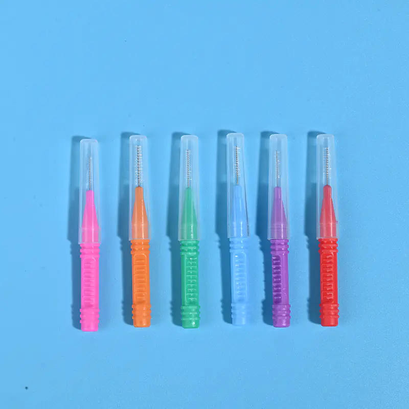 Six assorted color I-type interdental brushes with transparent protective caps lined up horizontally, ISO size marked dental supplies wholesale