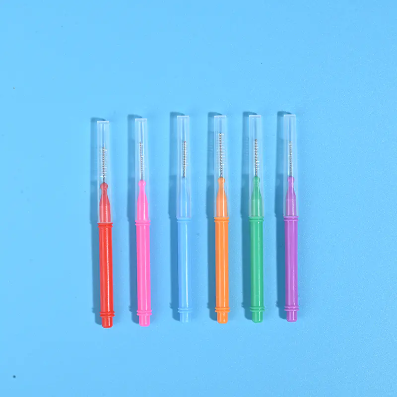 Six assorted color retractable I-type interdental brushes with clear dust protection cap lined vertically on solid bright blue background