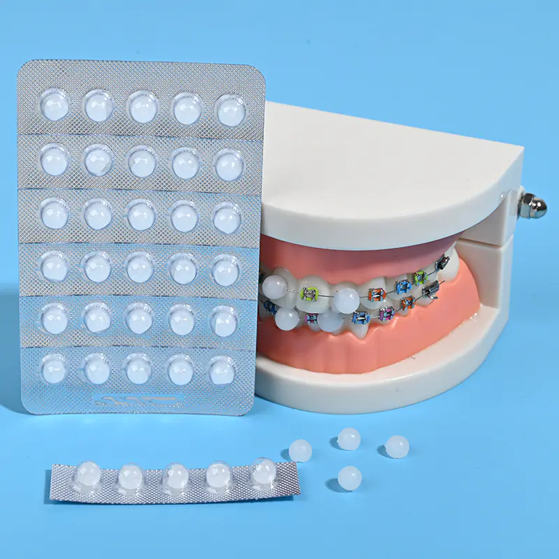 Full strip blister orthodontic wax placed beside orthodontic teeth model with metal brackets, bulk dental ortho supplies factory wholesale