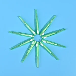 Transparent fresh green sliding push interdental brushes arranged radial star shape on solid light blue background